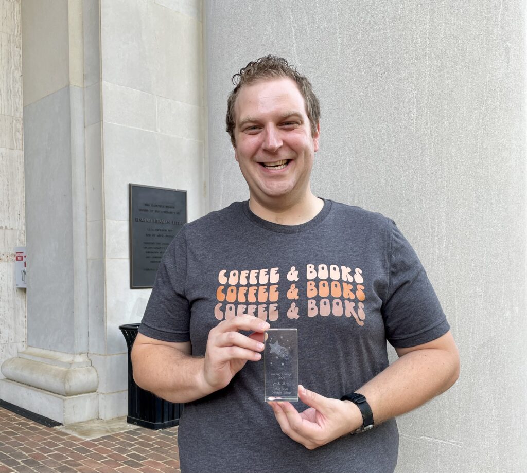 Matt Davis holding a crystal award.