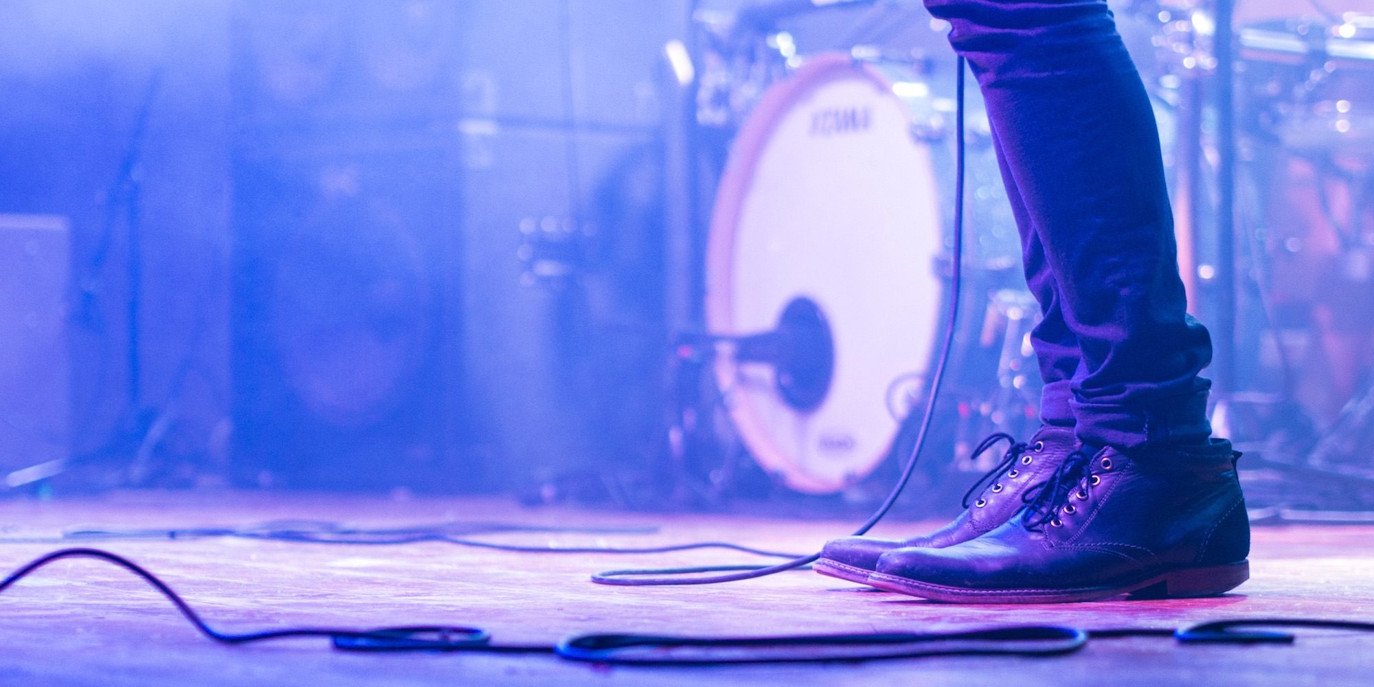 concert stage with drum kit and feet standing in front of