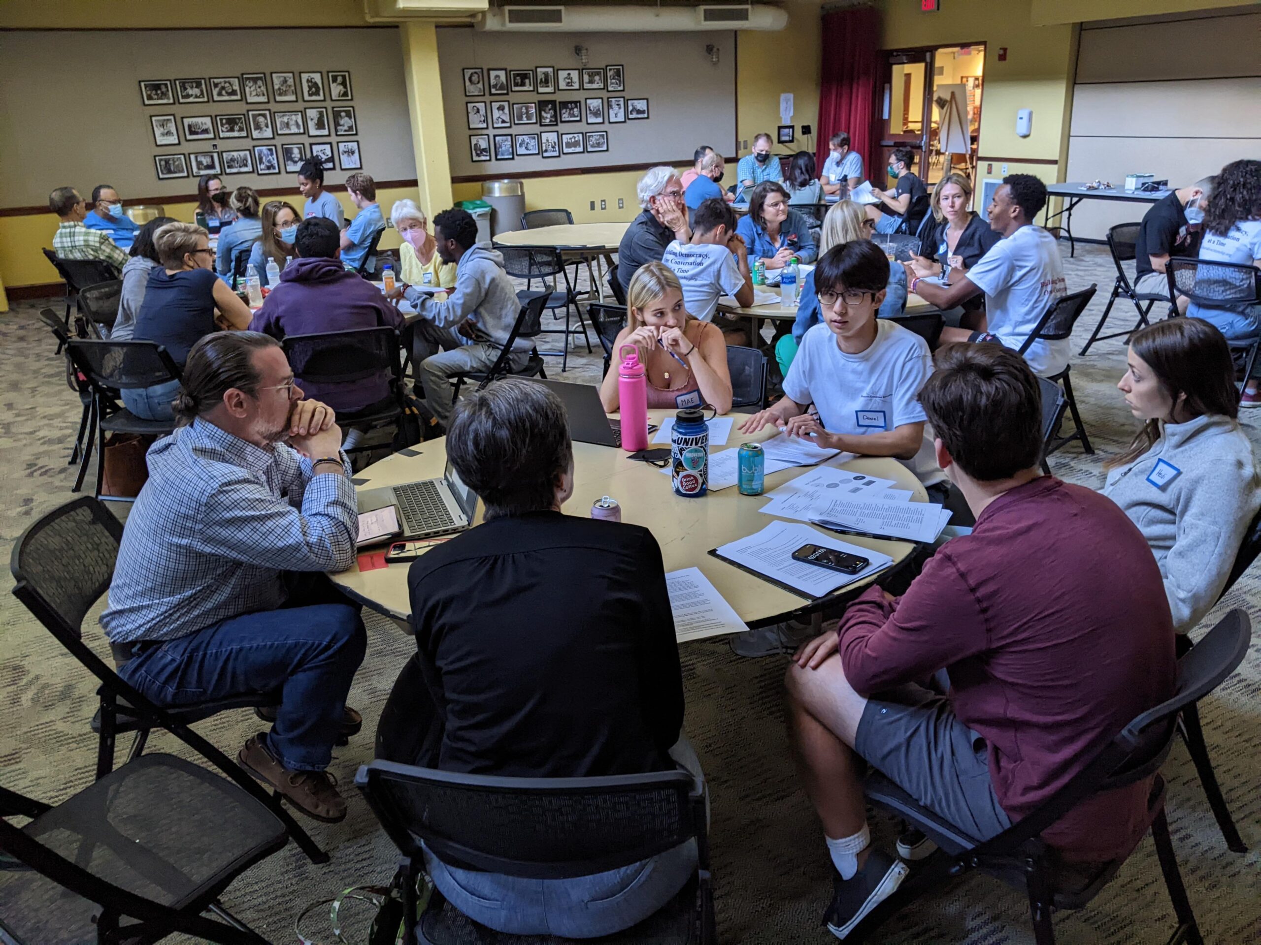 Students training for DCI Deliberations at round tables in the Davidson College 900 Room.