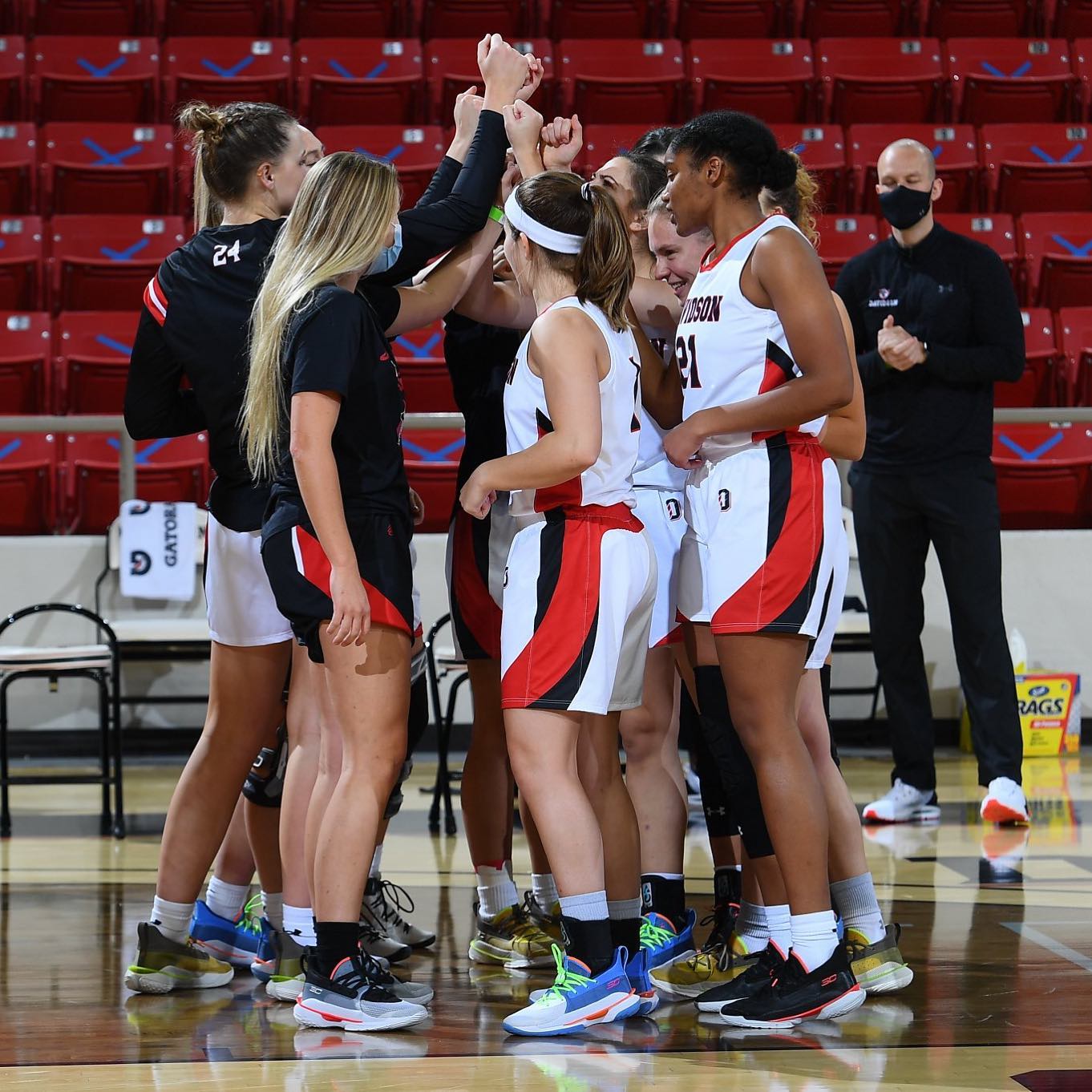 Davidson Women's Basketball Team huddled for a breakdown.