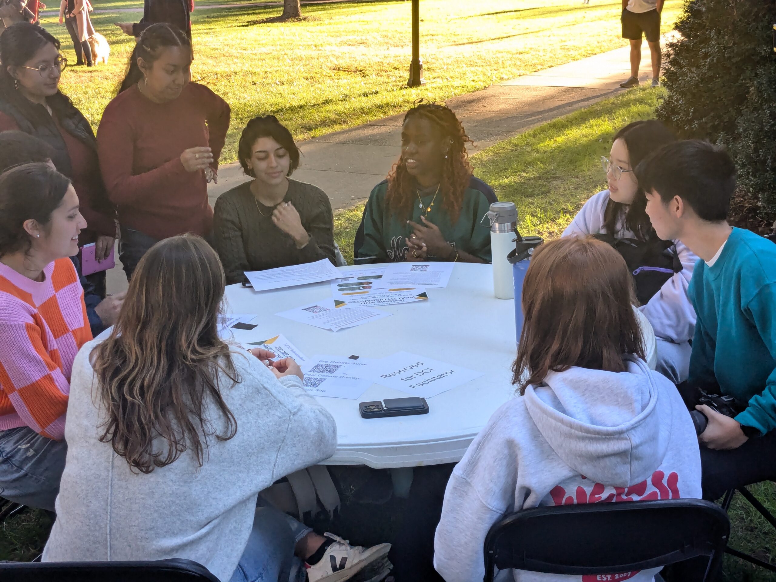 Students sitting around a  table talking.