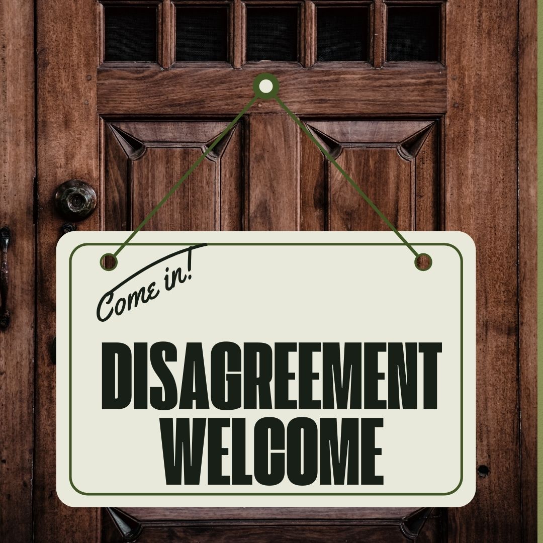 Wood door with sign saying, "Come in, Disagreement Welcome!"