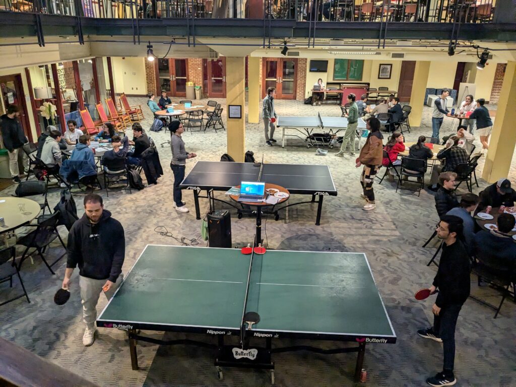 tables of people talking and playing ping pong