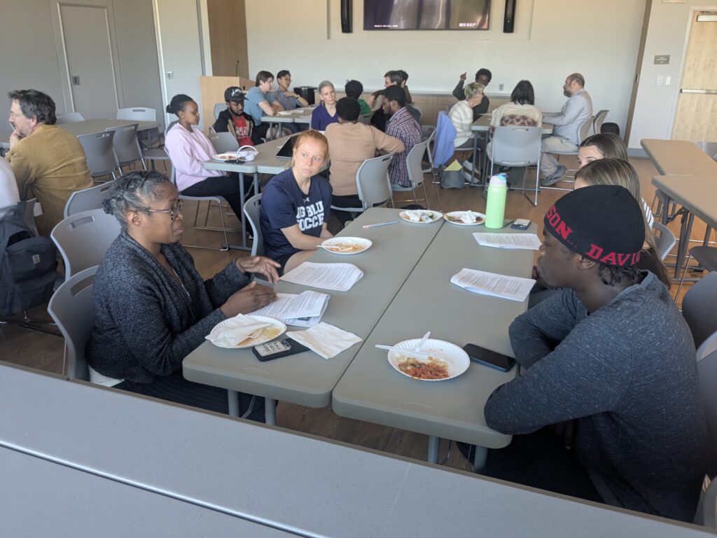 Audience discussing forum topic together around tables.