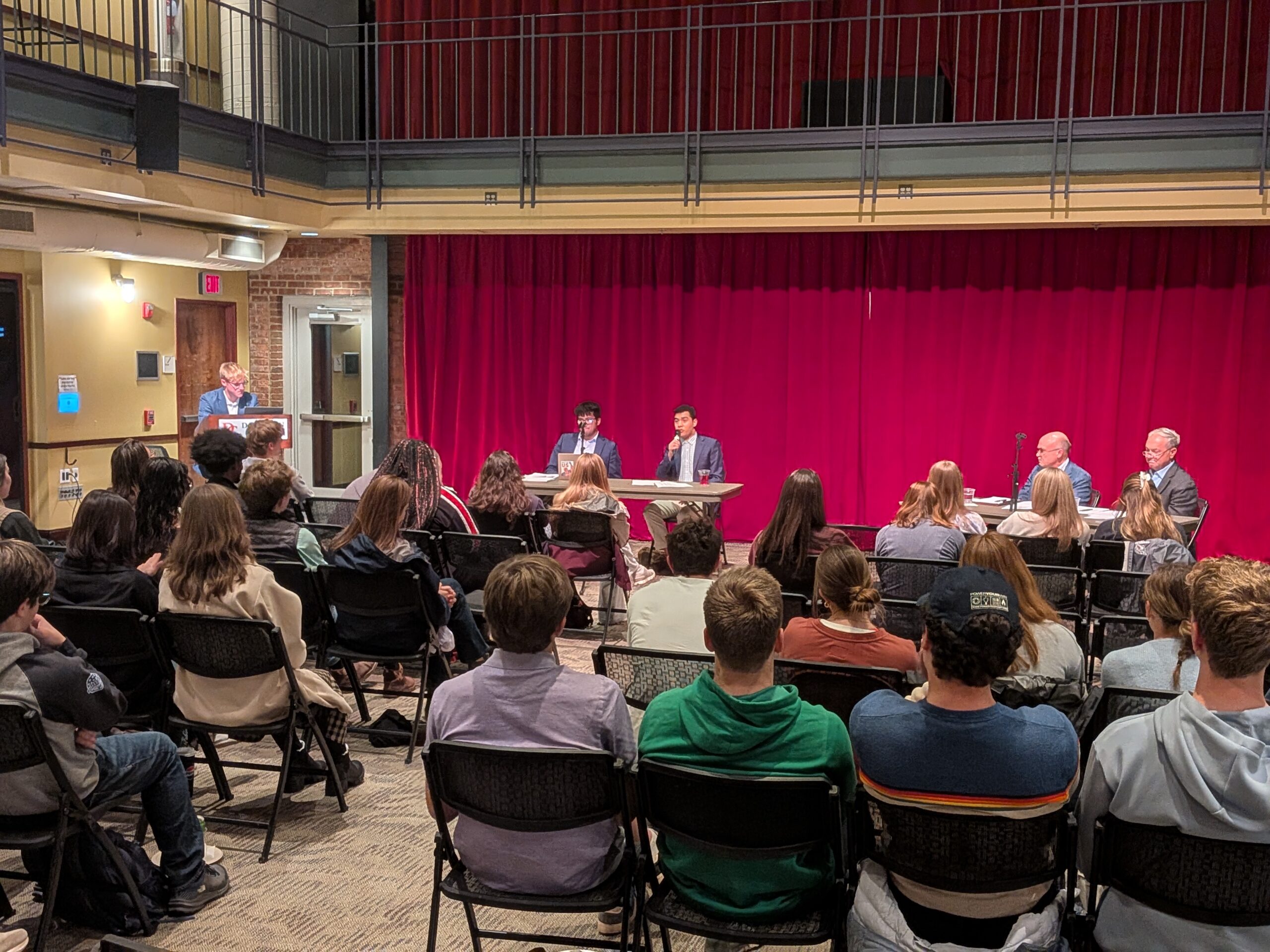 Photo of debaters sitting at tables