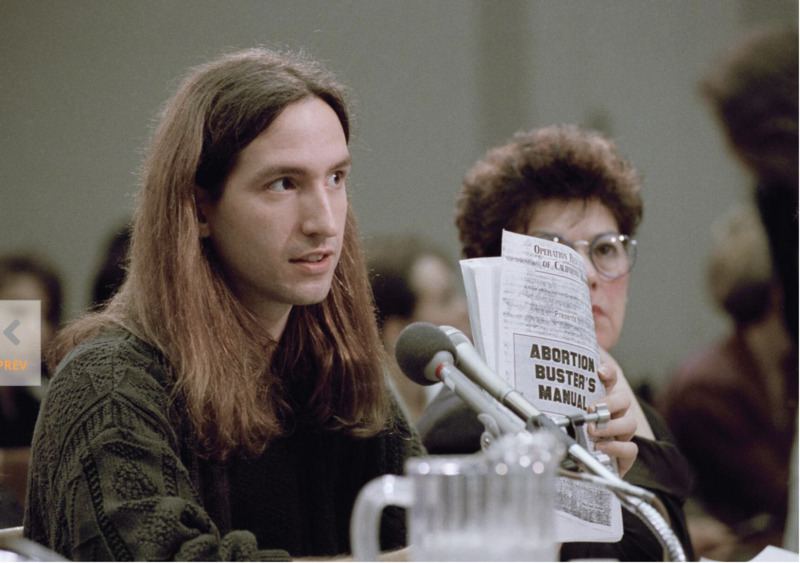 David Gunn Jr. holding a copy of "The Abortion Buster's Manual."