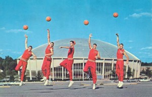 Davidson basketball team, 5 men jumping in the air off one foot and shooting the ball except the man in the middle is still holding the ball.