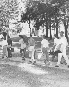 Students walking around Davidson with luggage