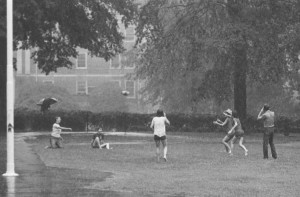 Students tossing football in the rain