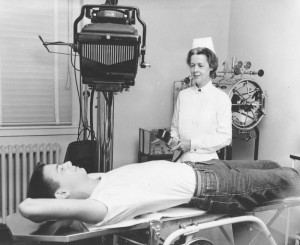 Infirmary nurse Sara Johnston with Charles Canter, class of demonstrating the x-ray machine