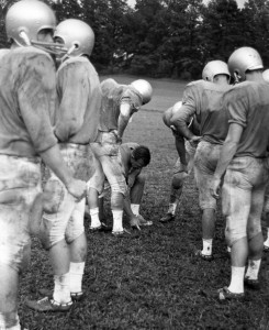 Pre-season training on the grass at Camp Carolina. Homer Smith illustrates his points on the turf