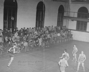 Basketball game in Alumni Gymnasium, stands are packed