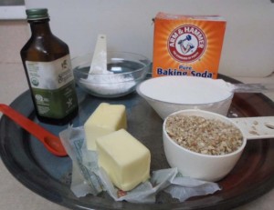 Ingredients neatly assembled, vanilla, Arm & Hammer Pure Baking Soda, flour, softened butter, powdered sugar, and a red spoon