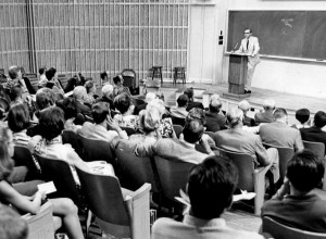 Davidson College President at a podium at the front of a classroom talking to alumni.