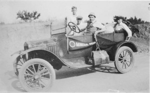 From Aubrey Brown scrapbook, an image of 4 men in a car with bags packed ready for a trip in 1929