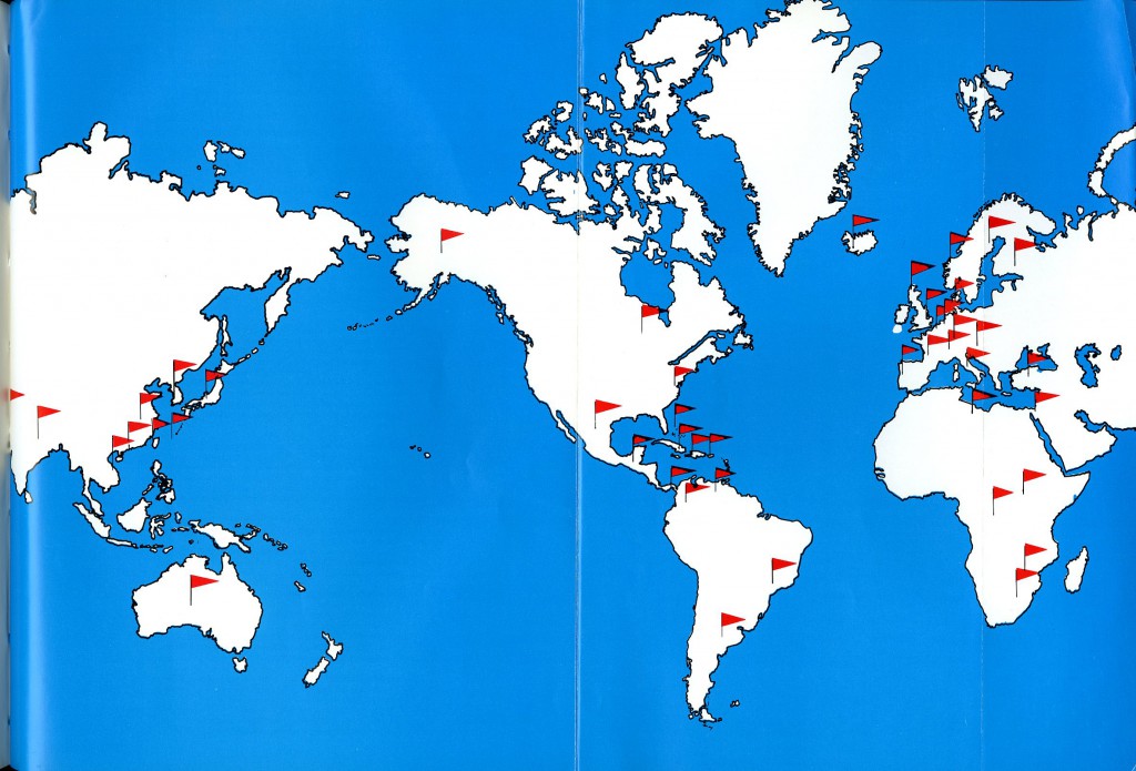 A map with blue ocean and white continents. Red flags marking where Davidson alumni were abroad in 1964