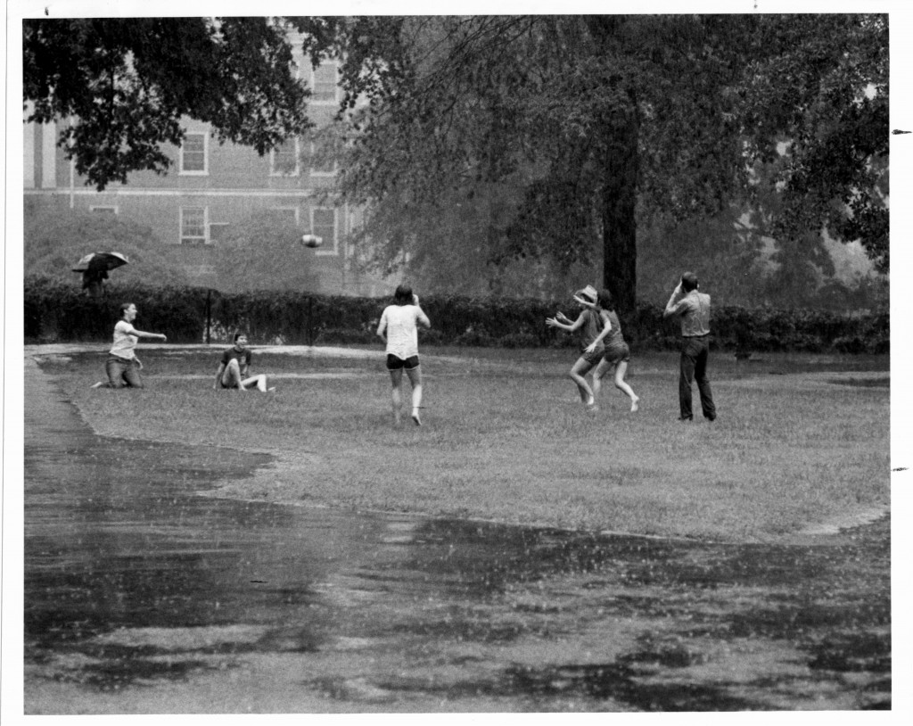 Davidson students tossing a football in the rain. The caption on the reverse of this photograph reads: "Social life. Flickerball in rain, Sept. '77."