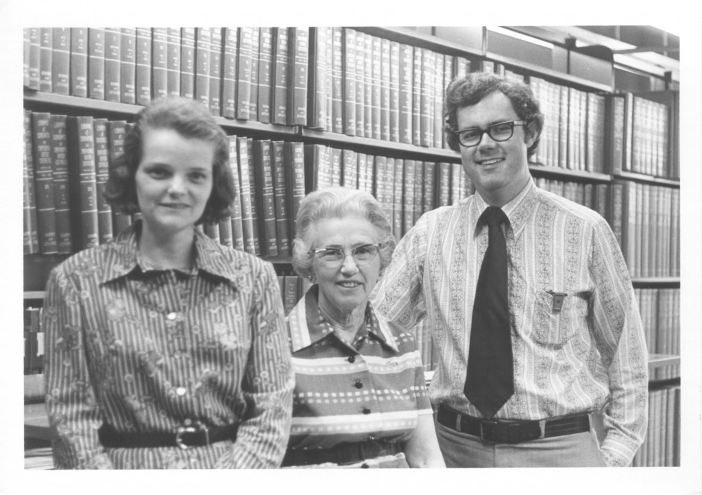 "Dr. Beaty, Ms. , and Dr. Park stand together in front of book Stacks in Grey Memorial Library." Circa 1972