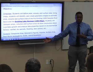 Erik Dykes convincing fellow teachers and Little Library staff that maps and math can work tofgether. Image of Erik standing in front of a projected computer screen.