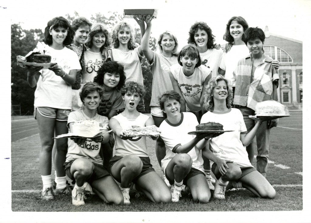 A group of freshmen women in the class of 1989 pose with their hard-earned cakes on the football field, August 1985.