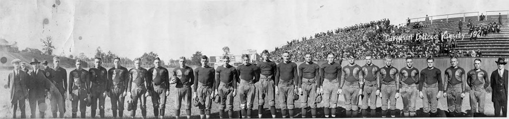 Varsity football team in 1921 with a stadium/field in the background