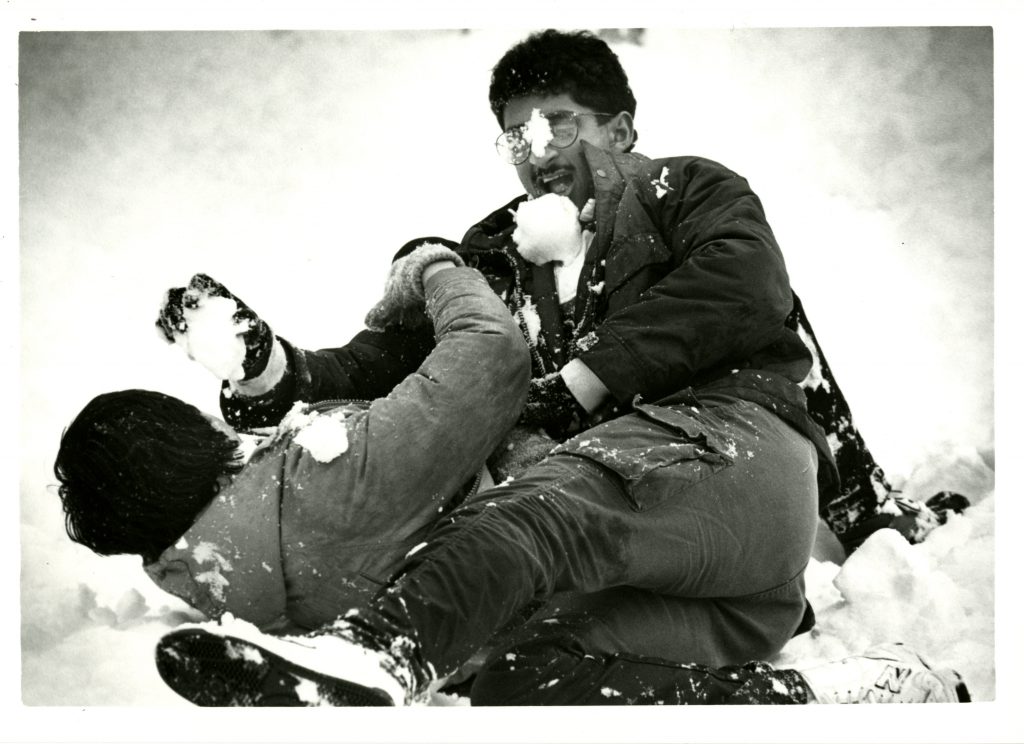 Two students engage in a rowdy snow fight on the ground, 1987.