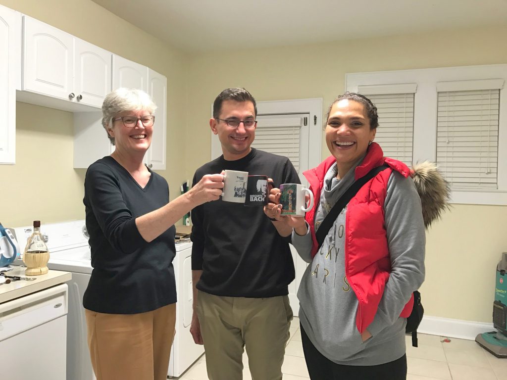 Jan Blodgett (College Archivists and Records Management Coordinator), Roman Utkin (Assistant Professor of Russian Studies), and Caroline Fache (Associate Professor of French & Francophone Studies) holding mugs enjoying the archival glogg.