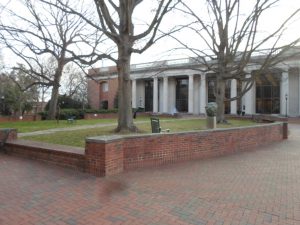 The left front side of E.H. Little Library behind the grassy area with sculptures and trees