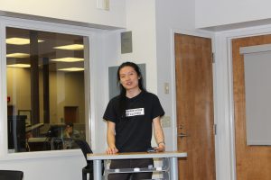 Man stands at podium in black shirt.