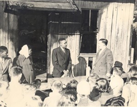 Photograph of the Lowery family meeting with Rev. Carl Prichett after the Brady’s Alley fire. 