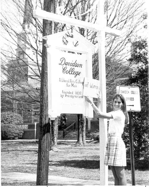 Student Sandra May holding a sign making it official that Davidson College is for men and women.