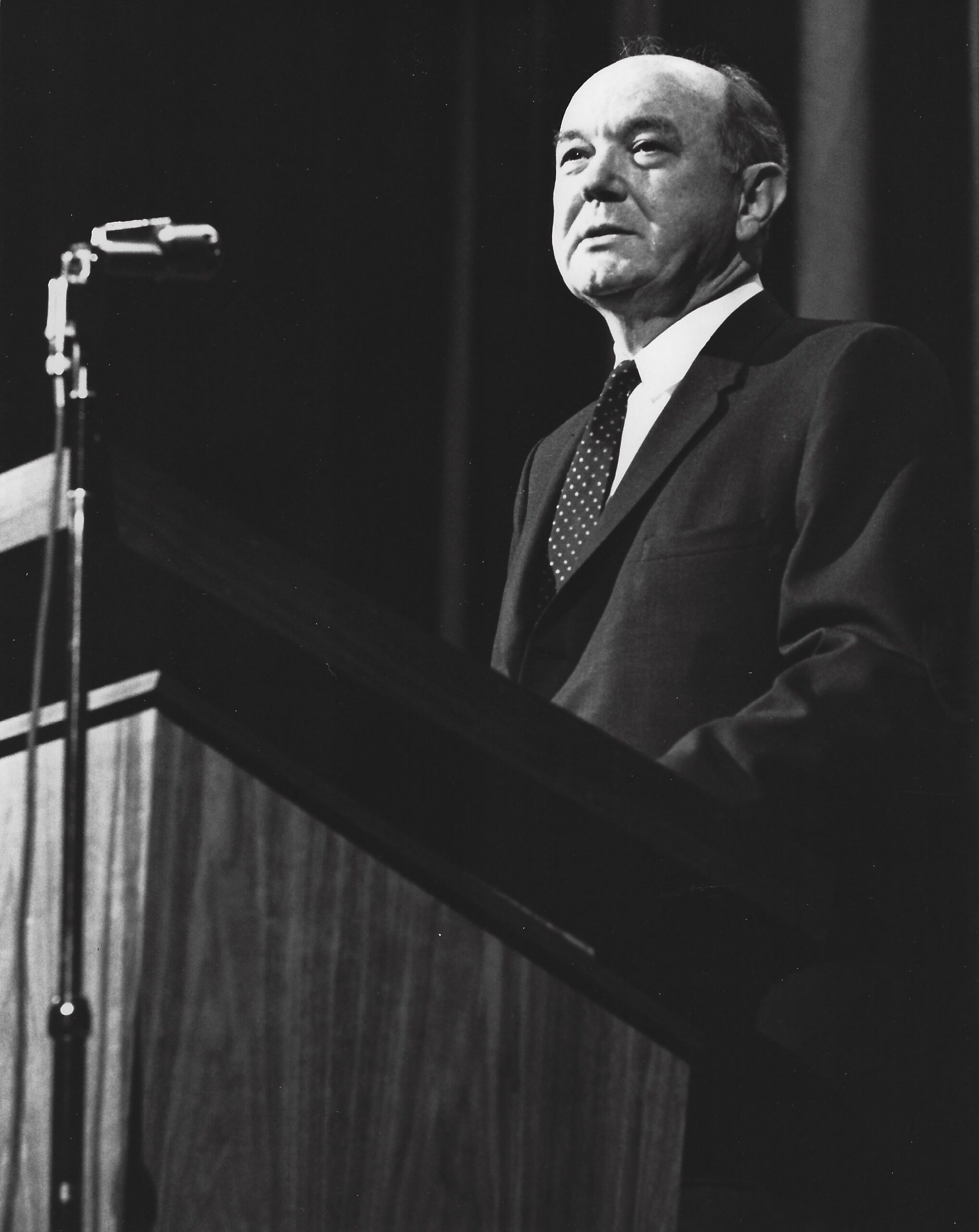 Dean Rusk standing in front of a podium