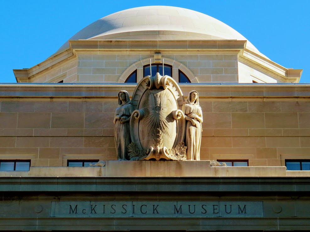 Color photo of statues on top of McKissick Museum 